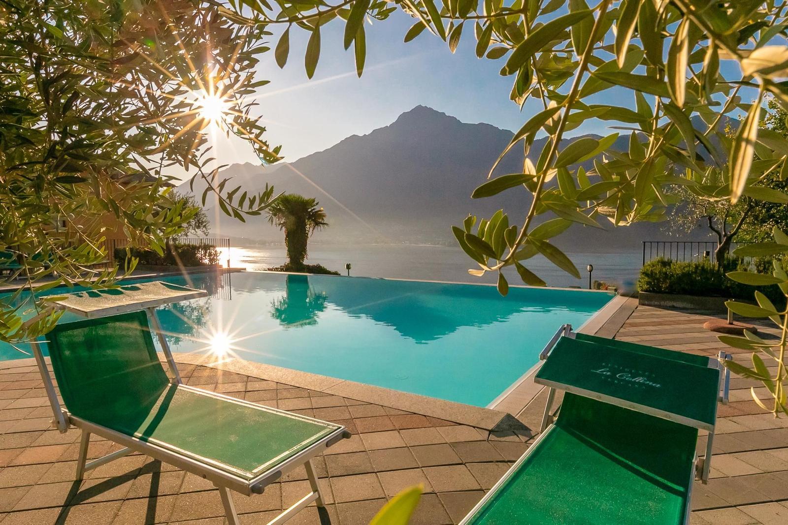 Nachtansicht eines Hotels mit Pool und beleuchtetem Baum.