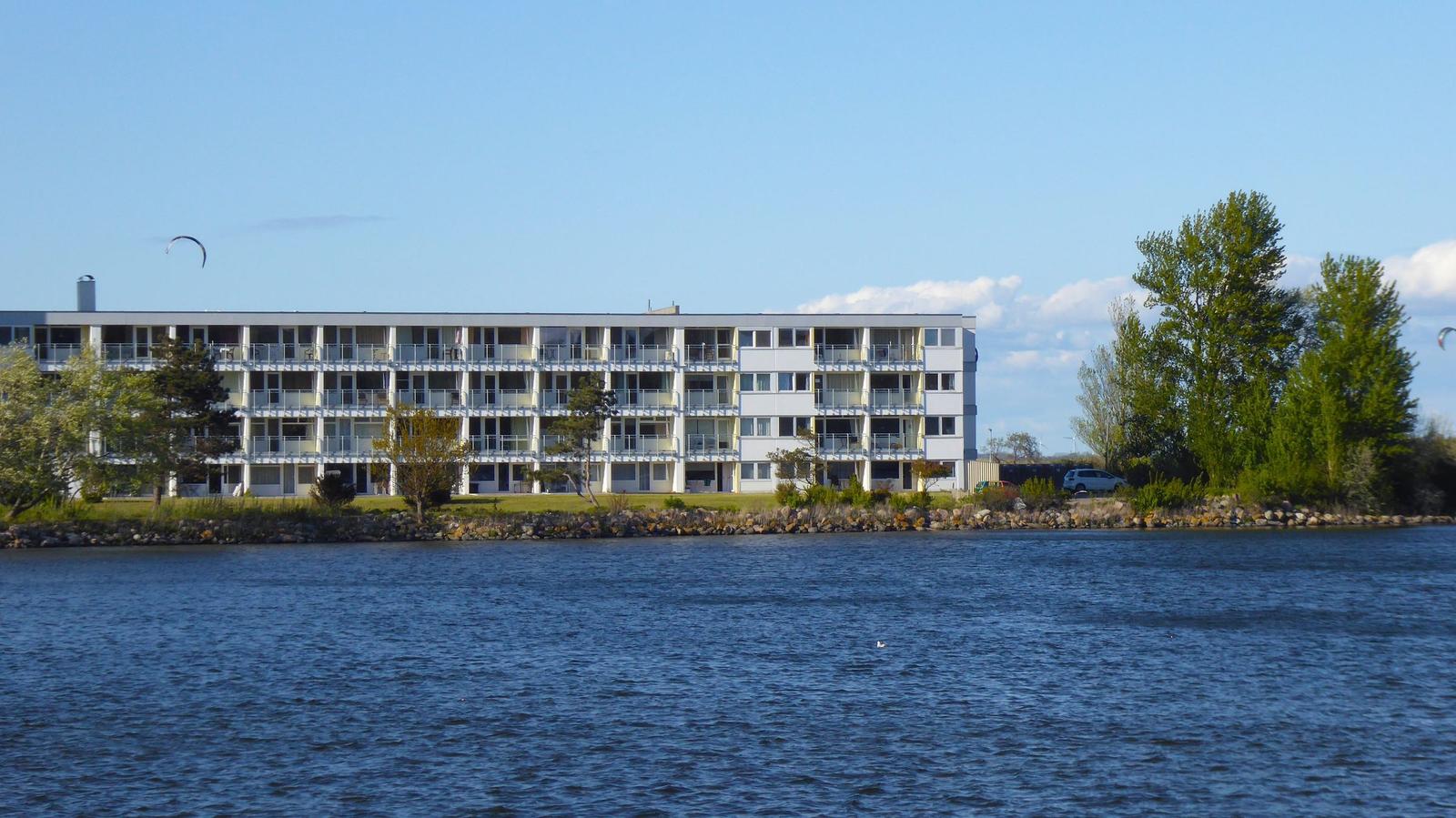 Holzsteg führt zum Strand mit Strandkörben und Blick aufs Meer.