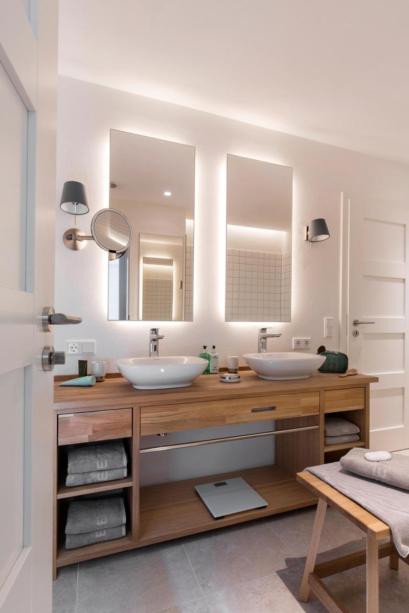 Holztisch mit Badewanne, Handtüchern und Seife vor Fenster