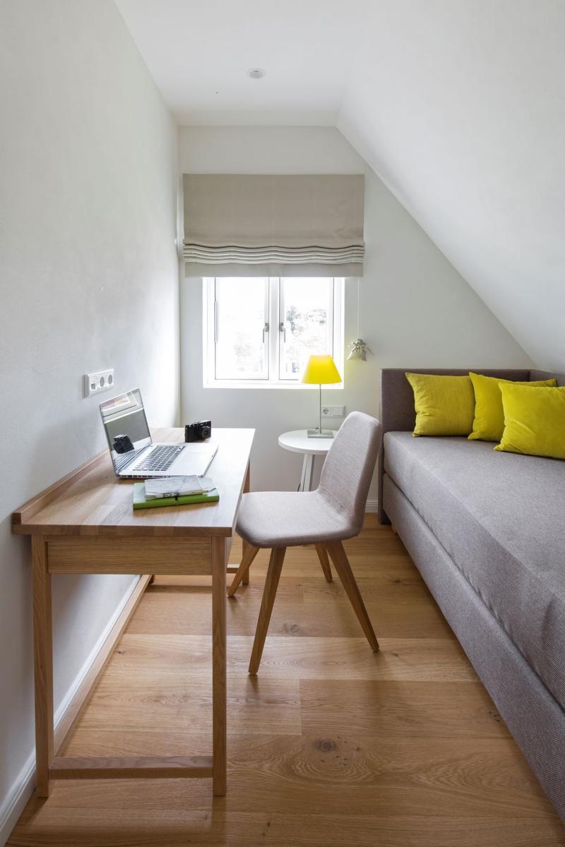 Ein Schlafzimmer mit Schreibtisch, Fernseher und Kleiderständer mit Kleid.