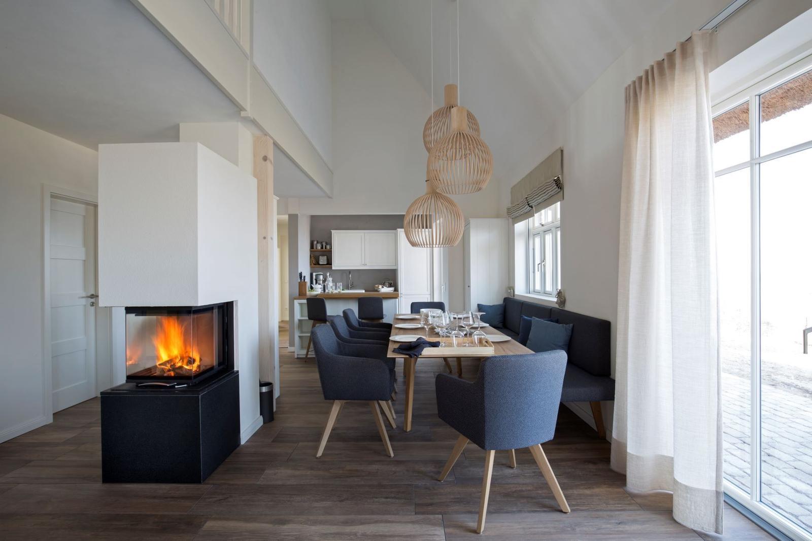 Wohnzimmer mit Sofa, Fernseher und hängenden Lampen.