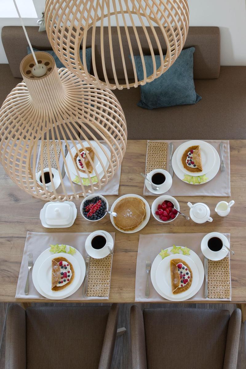 Esstisch mit Frühstück, Wohnbereich mit Sofa und Holzdecke