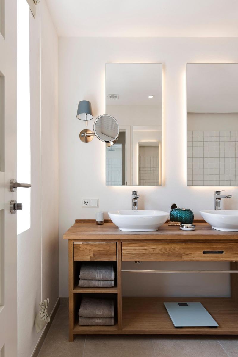 Wooden table with bathtub, towels, and soap by window