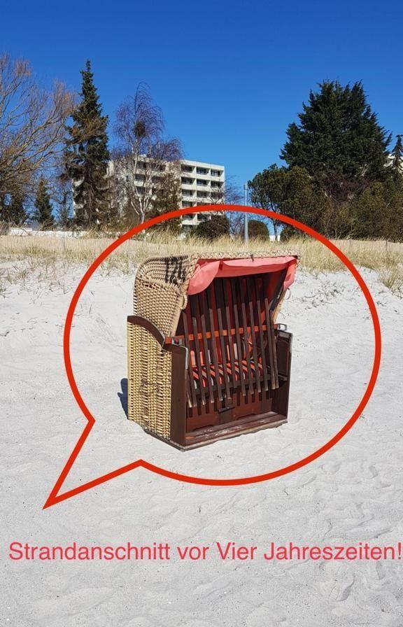 Küche mit Holzschränken, rotem Kühlschrank und integriertem Backofen.