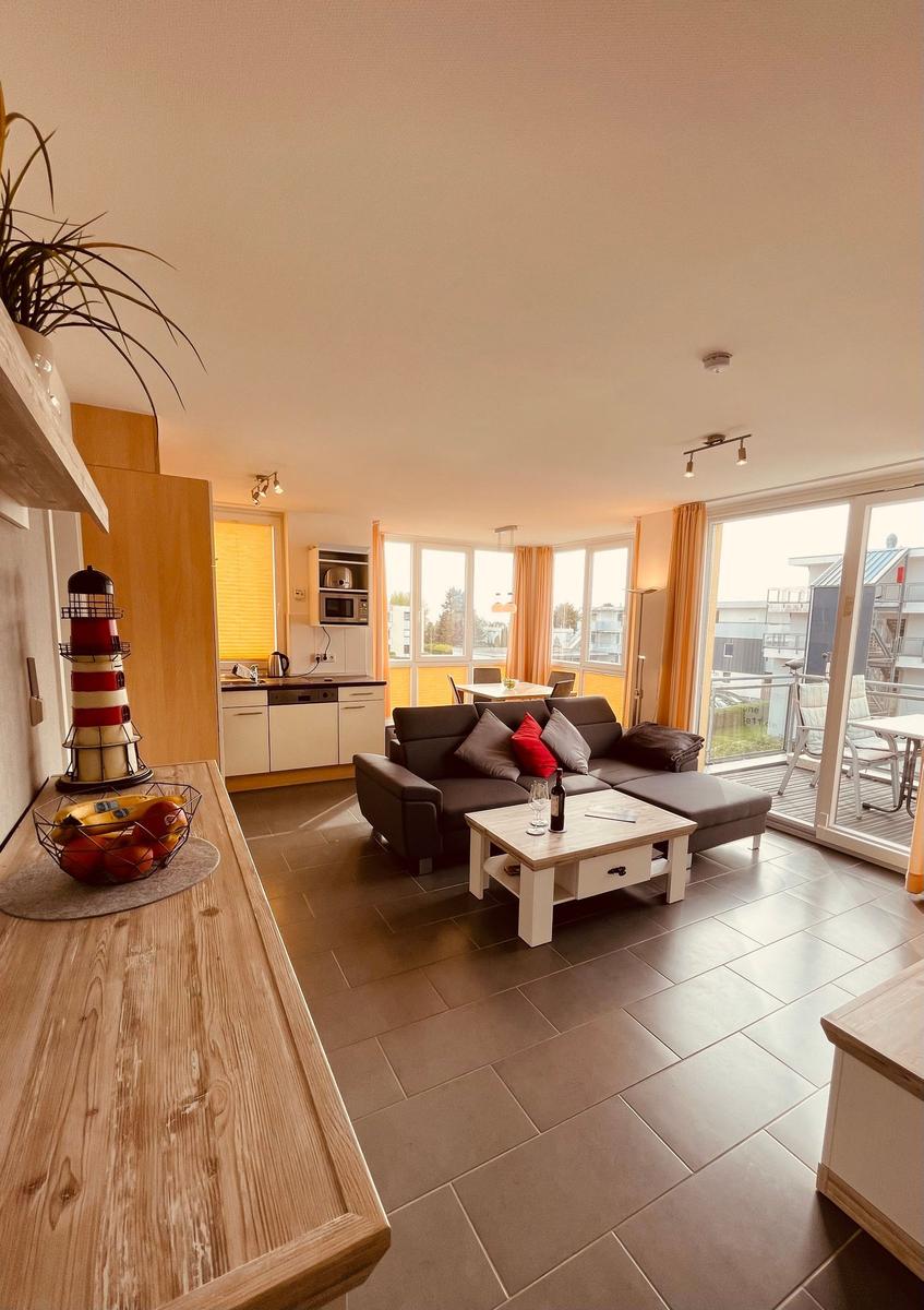 Wohnzimmer mit Sofa, Couchtisch und Küchenbereich mit moderner Ausstattung.
