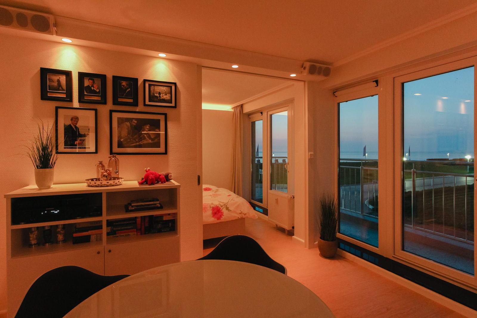 Wohnung mit Schlafzimmer, Wohnbereich, Bad und Küche. Balkon mit Sitzgelegenheiten.