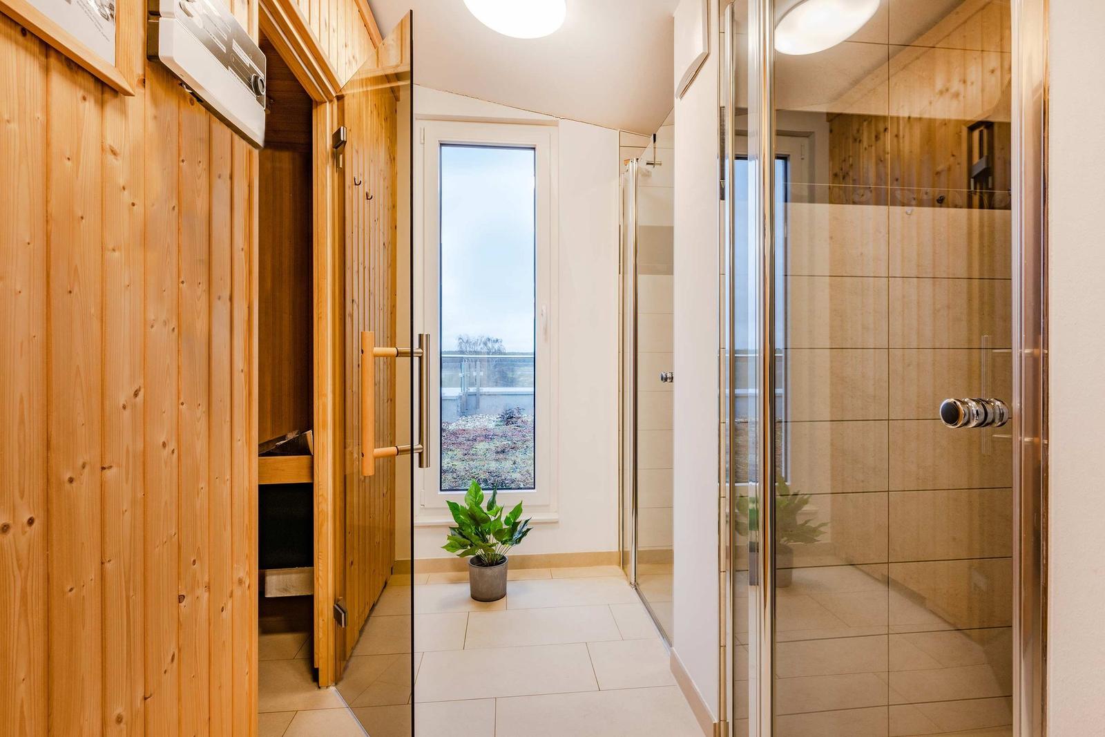 Sauna mit Holzbank, Thermometer und Eimer mit Löffel.