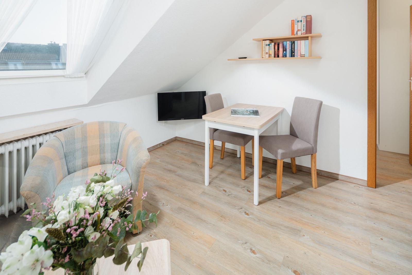 Zimmer mit zwei Betten, Dachschrägen, Dachfenster und Holzboden.