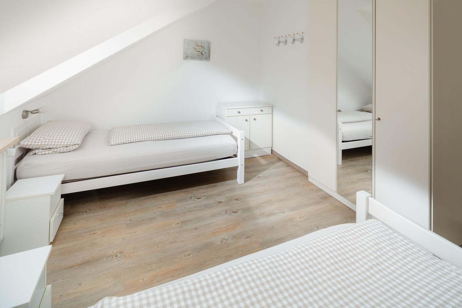 Badezimmer mit Dusche, Toilette und Waschbecken. Fliesenwand und Boden.