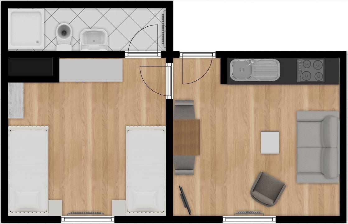 Wohnraum mit Sofa, Sessel, Tisch und Schreibtisch unter Dachschrägen.