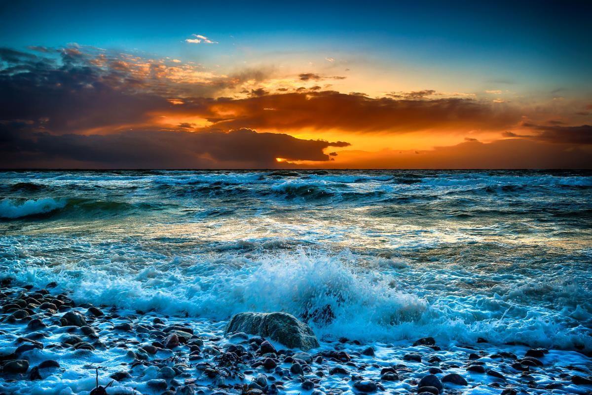 Sonnenuntergang über dem Meer mit farbigen Wolken am Horizont.