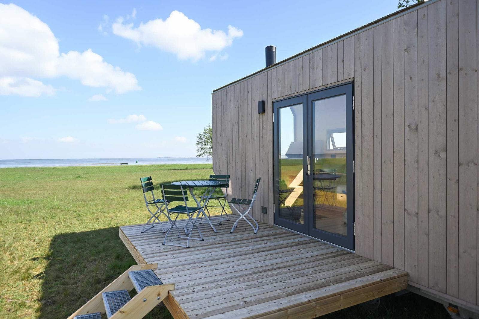 Schlafzimmer mit Bett, Holzwand und Dachfenster.
