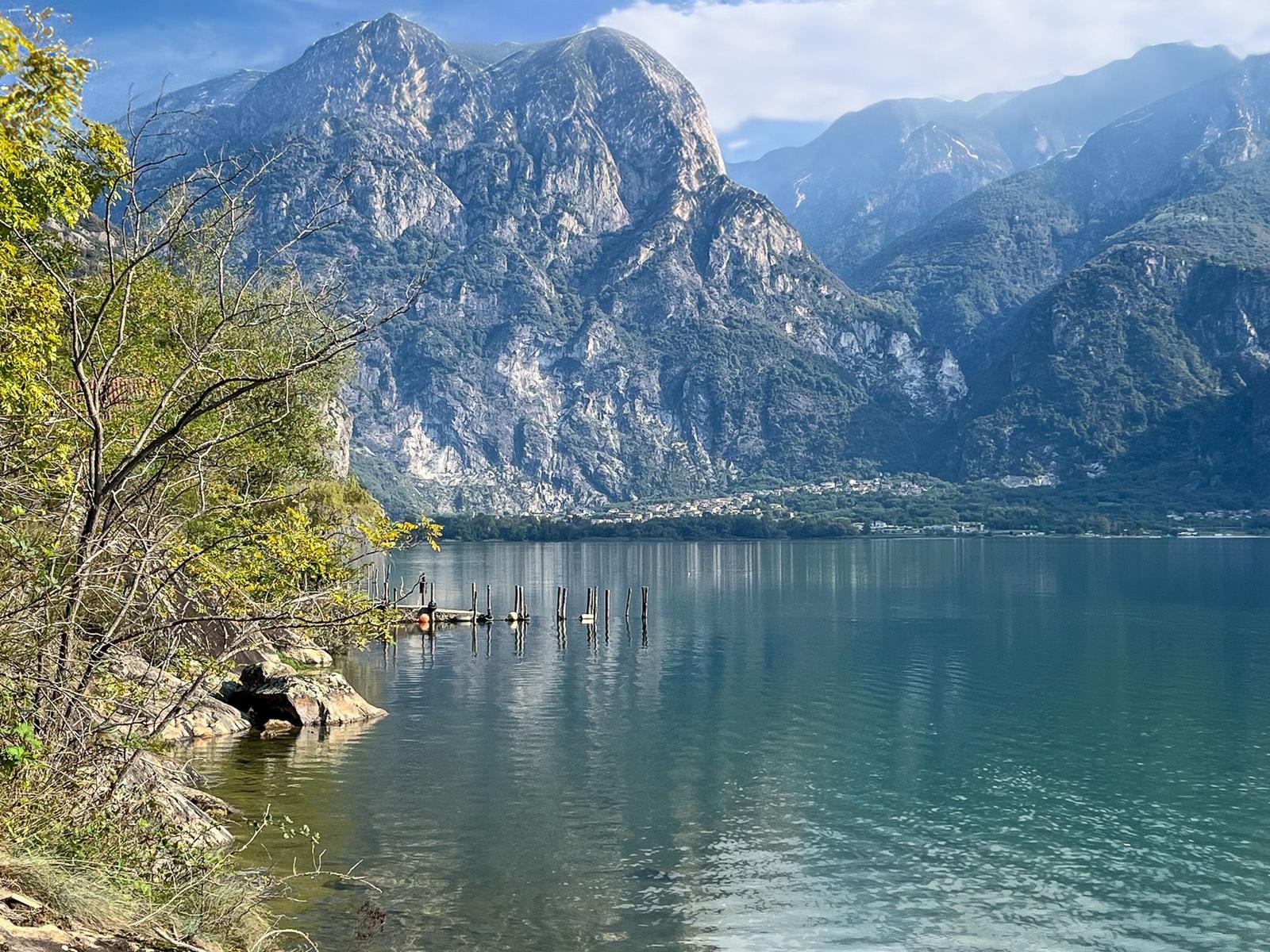 Panoramic view of a lake between mountains with settlements along the shore.