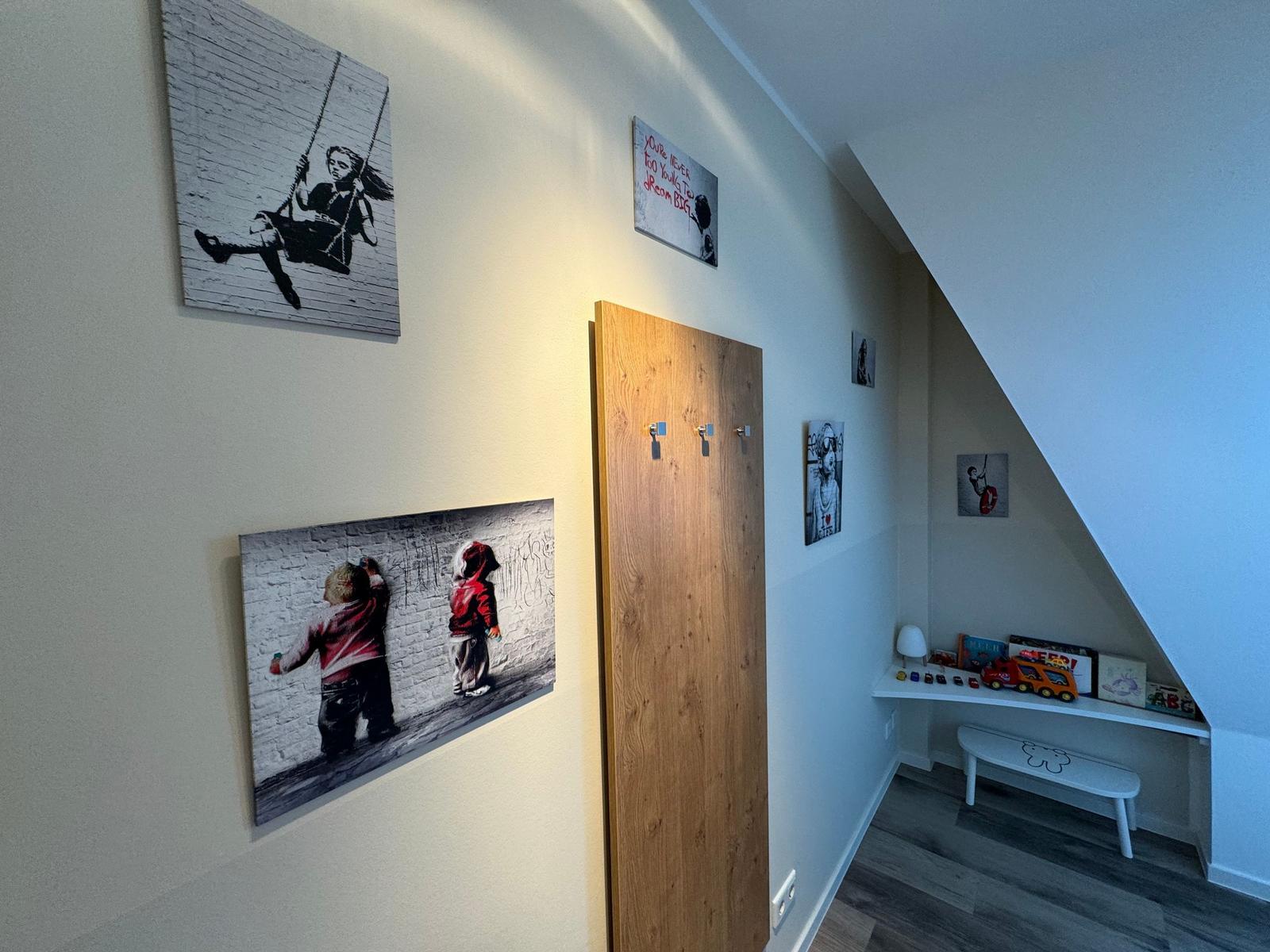 Kinderzimmer mit Schreibtisch, Stuhl und Spielzeug.