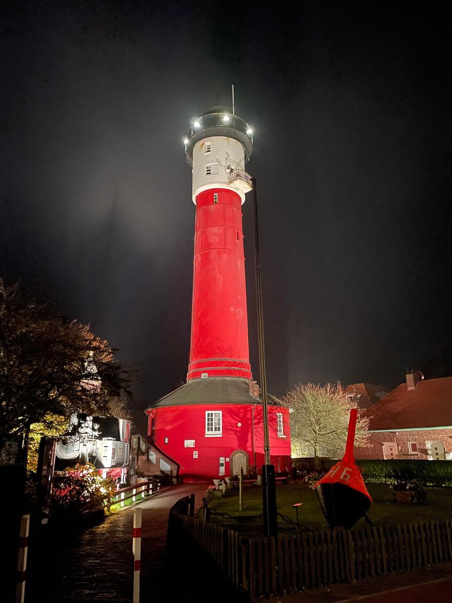 Zweistöckiges Backsteinhaus mit Balkonen und grauem Dach unter bewölktem Himmel.