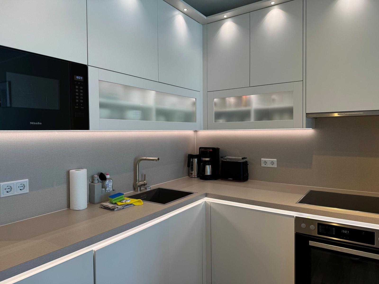 Essbereich mit Tisch, vier Stühlen und Hängelampe. Fernseher und Kleiderschrank sind sichtbar.