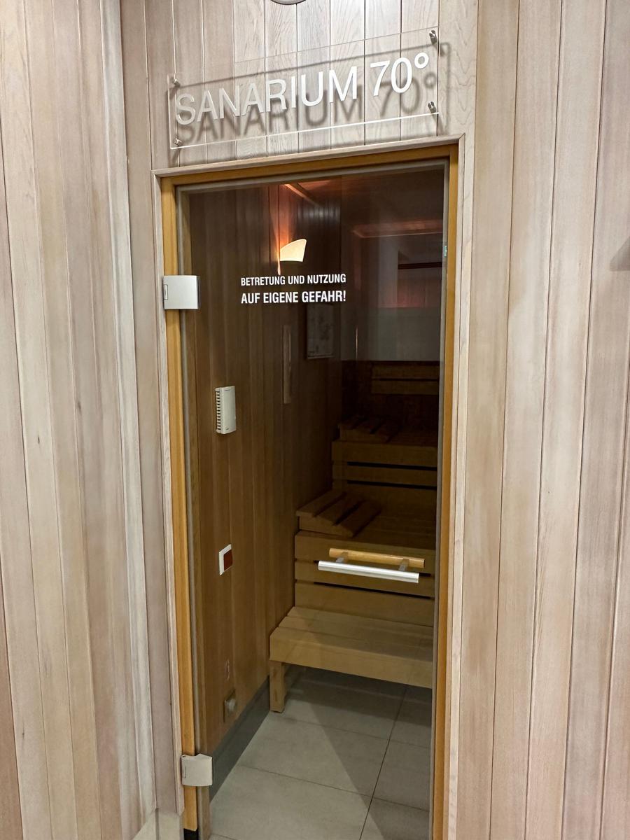 Sauna und Dusche im Wellnessbereich mit Holzwand und Uhr