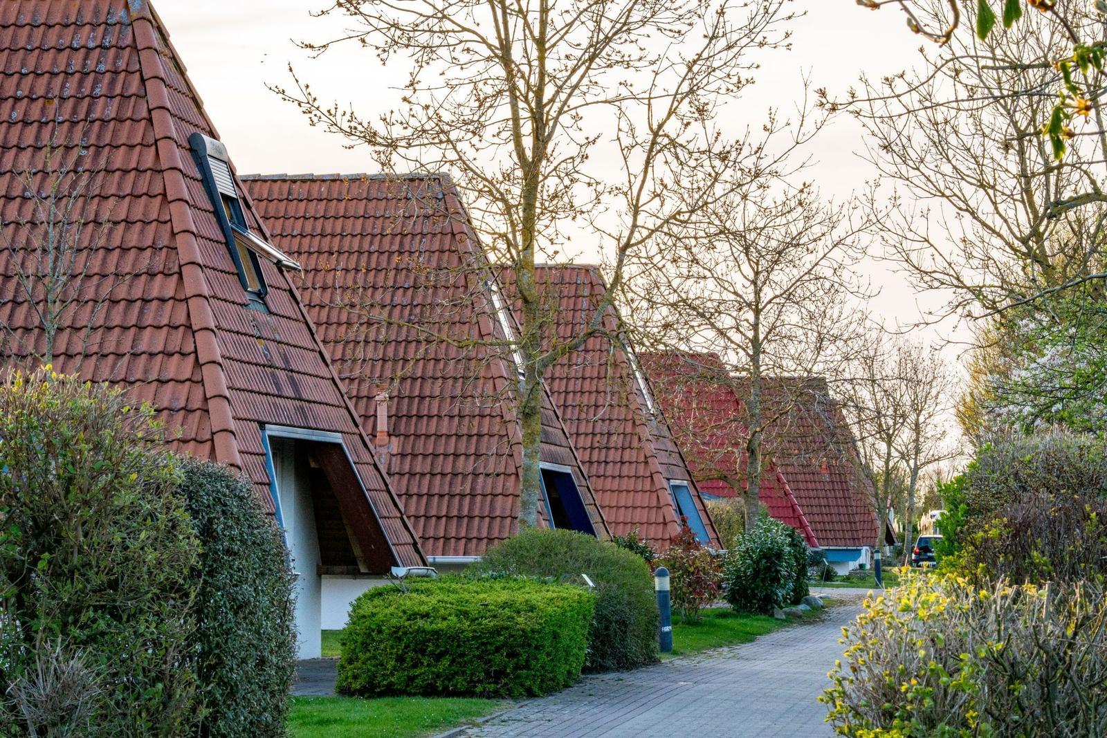 A road leads to a lighthouse with metal staircases and green vegetation on the sides.