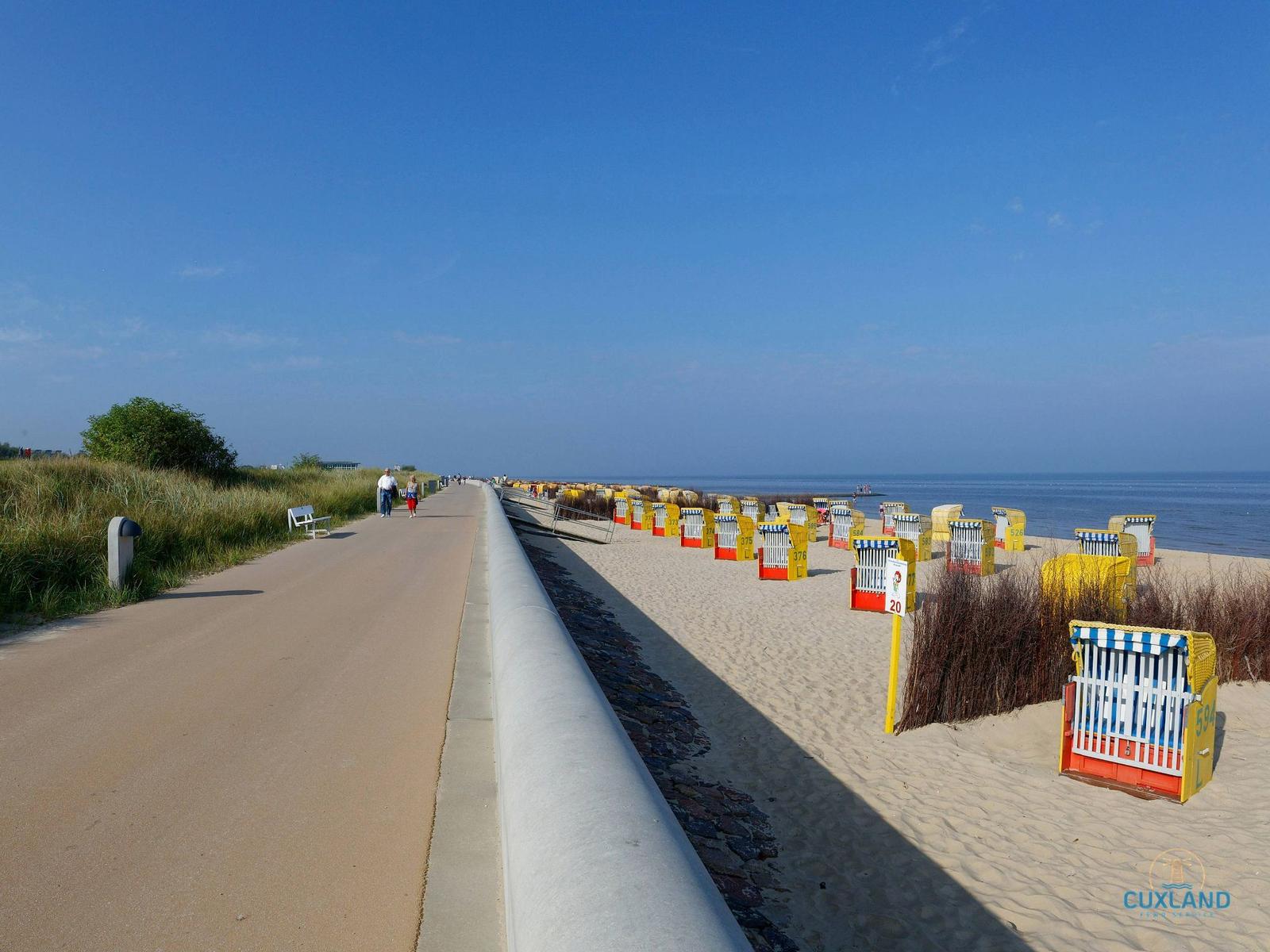 Weg zum hölzernen Leuchtturm am Strand mit Blick auf das Meer.