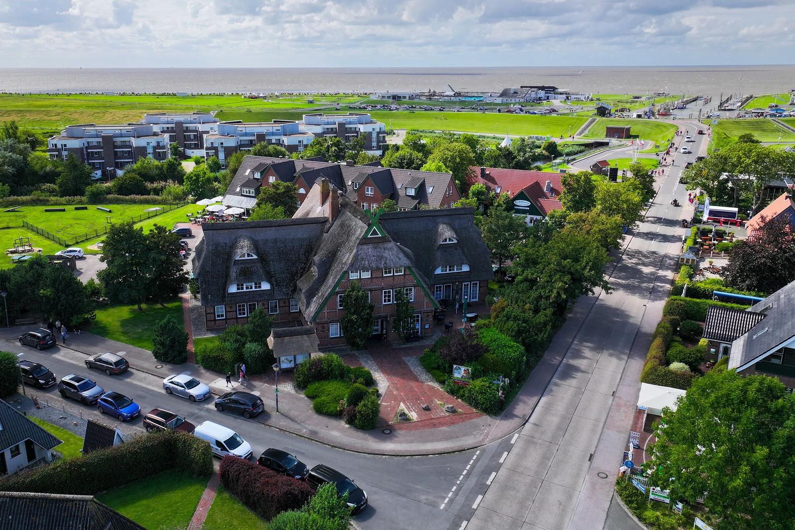 Willkommen-Schild an Haus mit Regenstiefeln und Steinweg