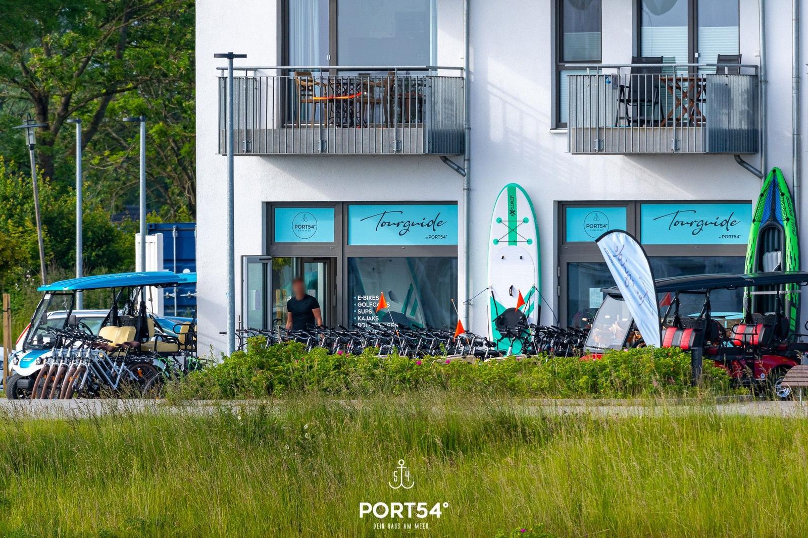 Strand mit Strandkörben und Wellen im Hintergrund.