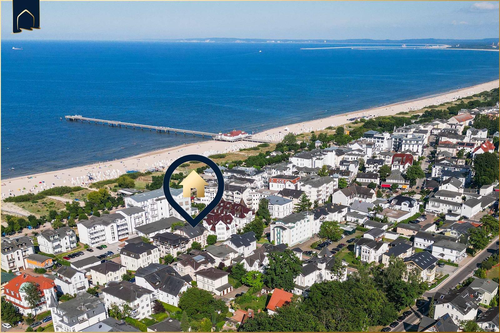Zwei weiße Bademäntel und eine gefaltete Handtuchrolle liegen auf einem Bett mit einer blauen Flasche.