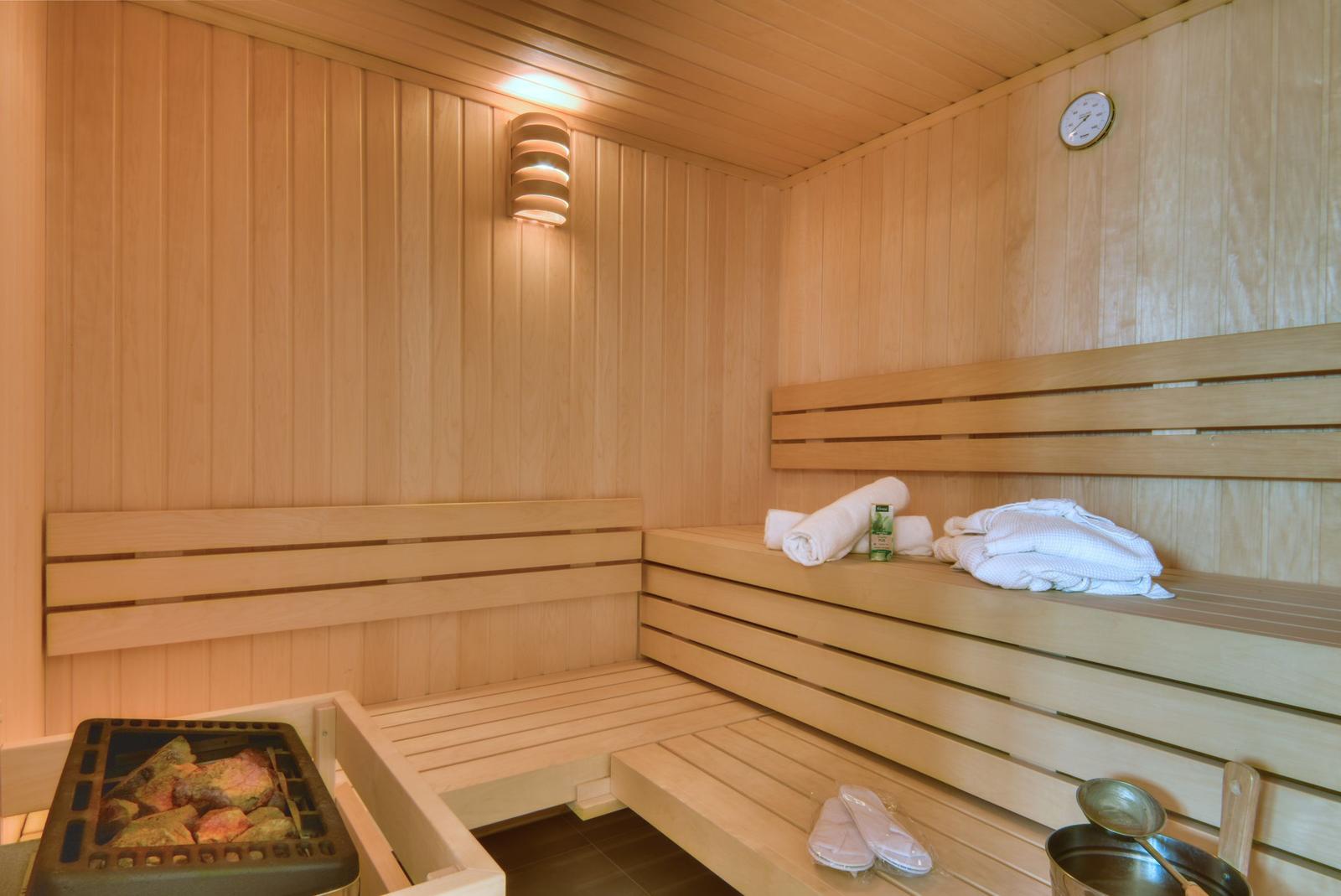Sauna mit Liege und Dusche im Badezimmer