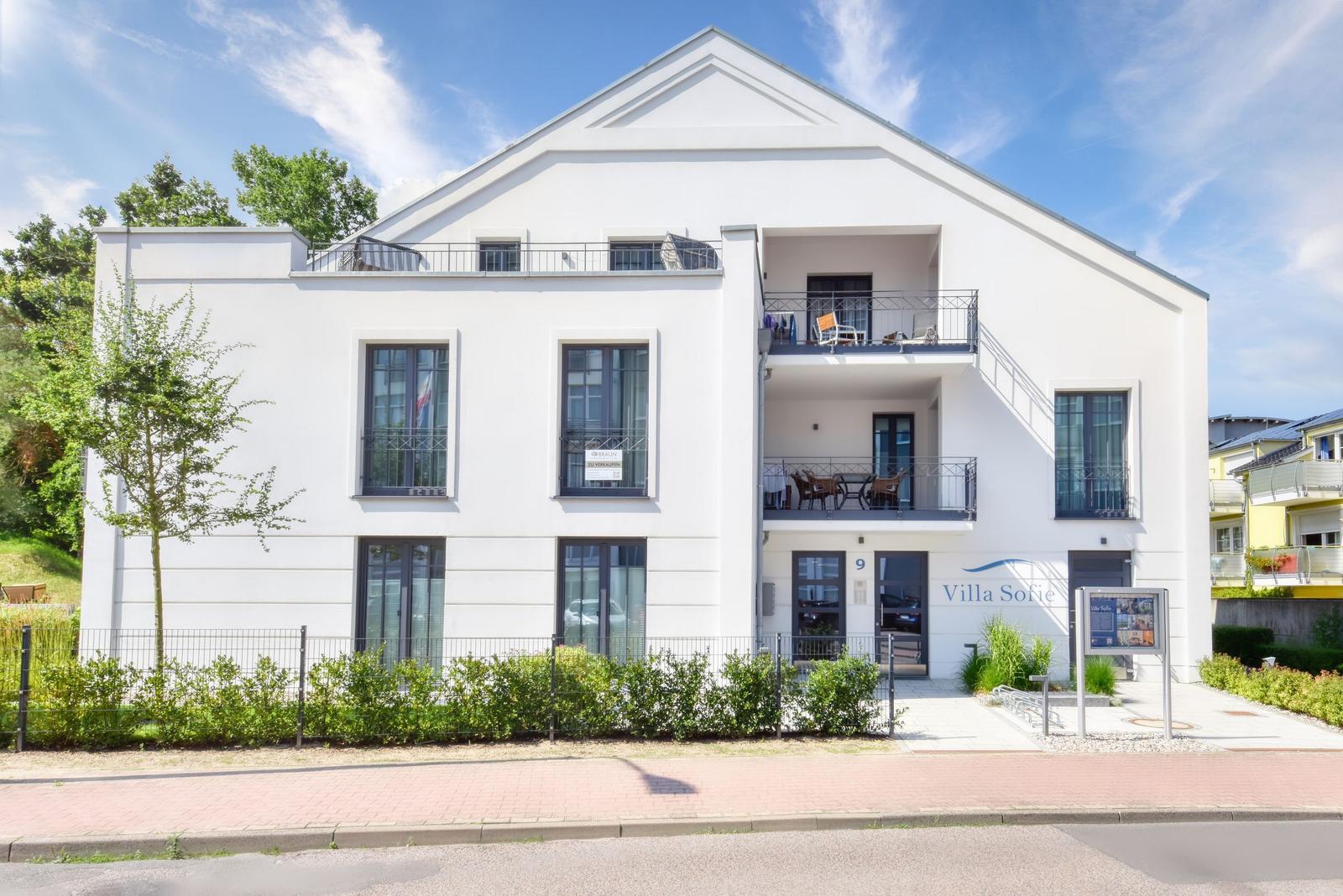 Villa Sofie mit Eingang, Balkon und gepflastertem Vorplatz.
