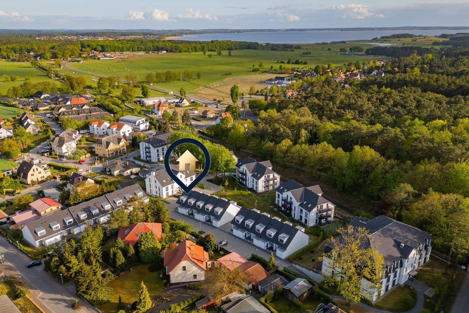 Bootshafen mit Segelyachten und roten Flaggen unter Bäumen