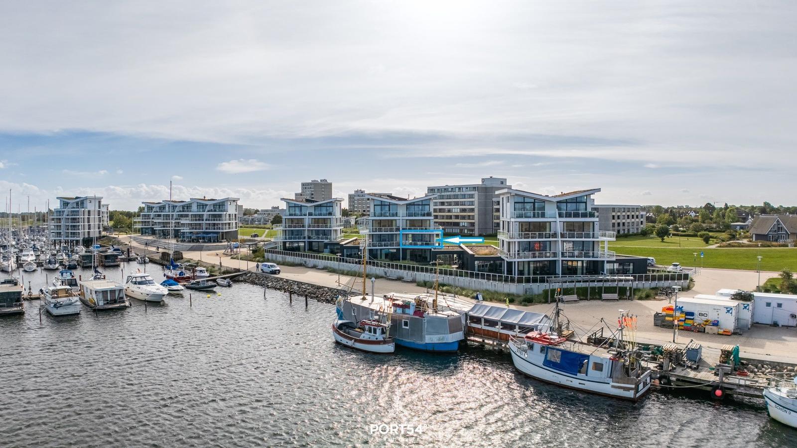 Hafen mit Booten und modernen Wohngebäuden an der Waterkant.