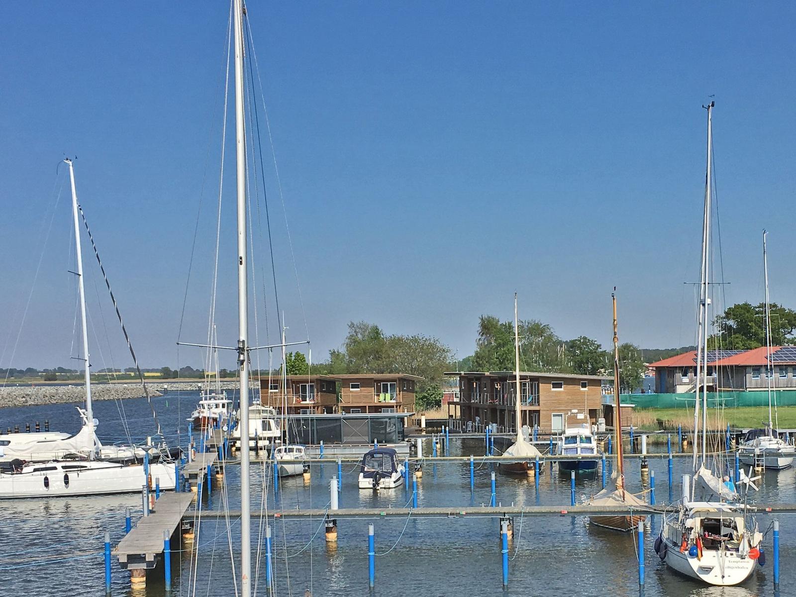 Boot liegt am Steg im Hafen. Blick auf Wasser und Ufer.