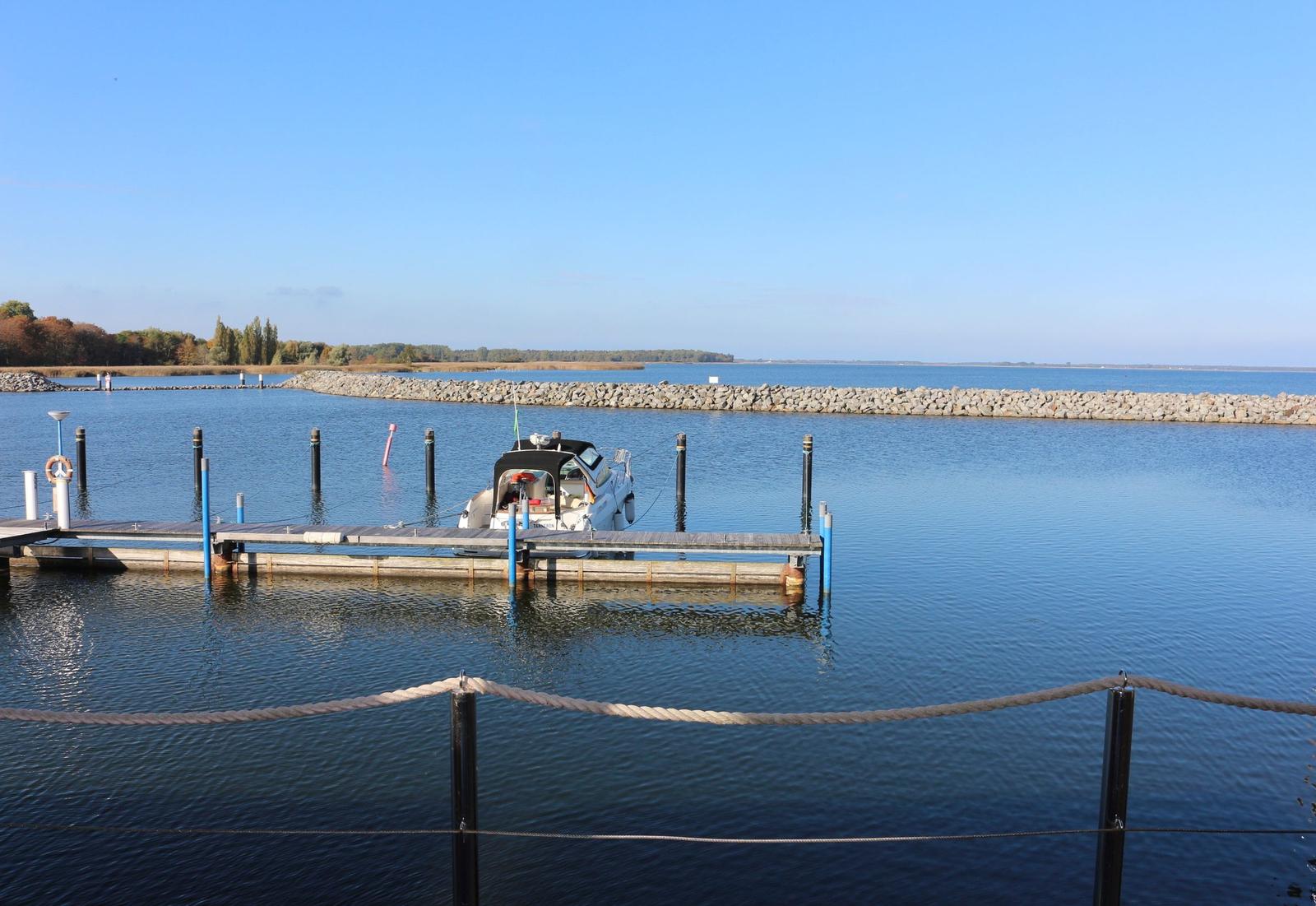 Holzhaus auf Wasser mit Terrasse und Booten im Hintergrund