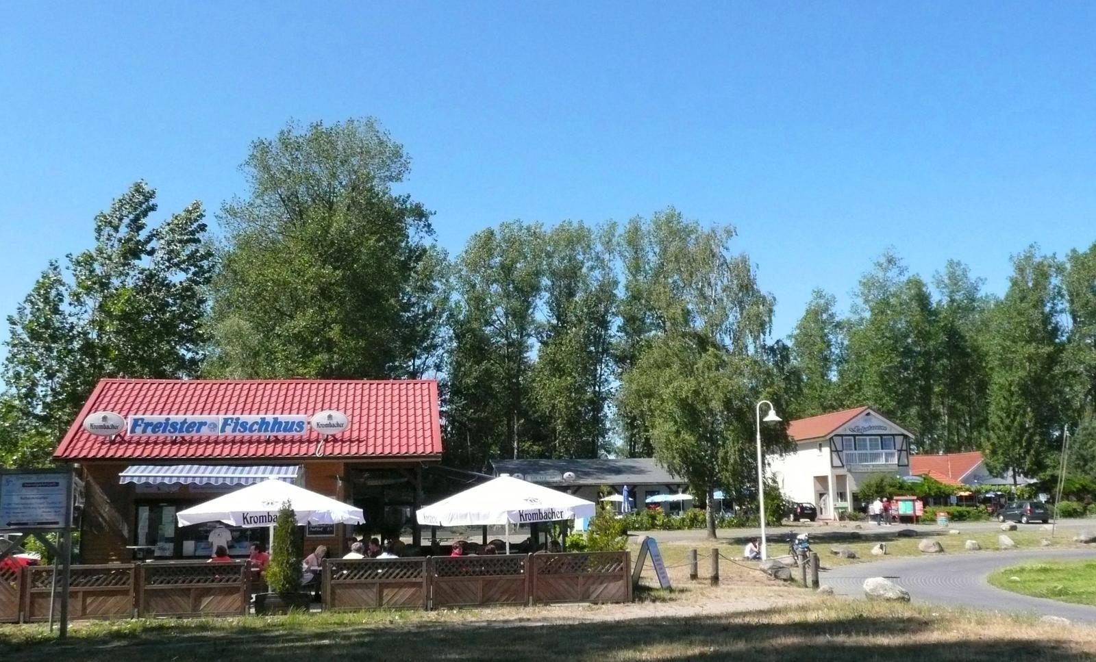 Zwei Schlafzimmer, Wohnbereich, Flur und Essbereich mit Tisch und Stühlen.