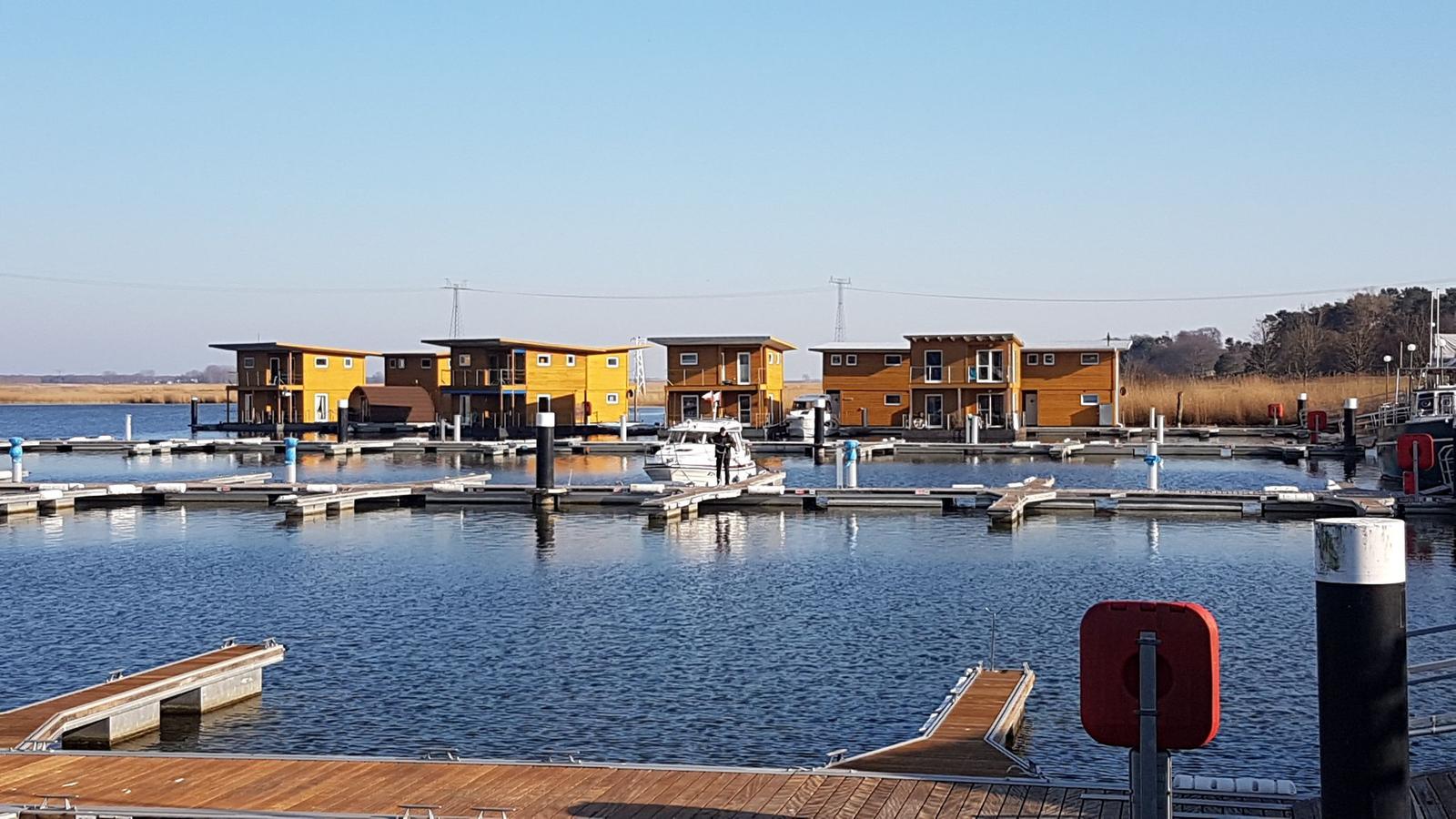 Hafen mit vielen Booten und Yachten im ruhigen Wasser unter blauem Himmel.
