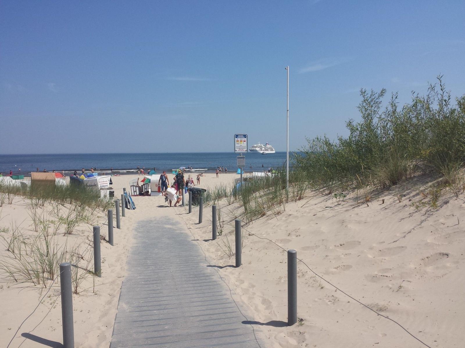 Pferd zieht Wagen mit Strandkörben am Strand.