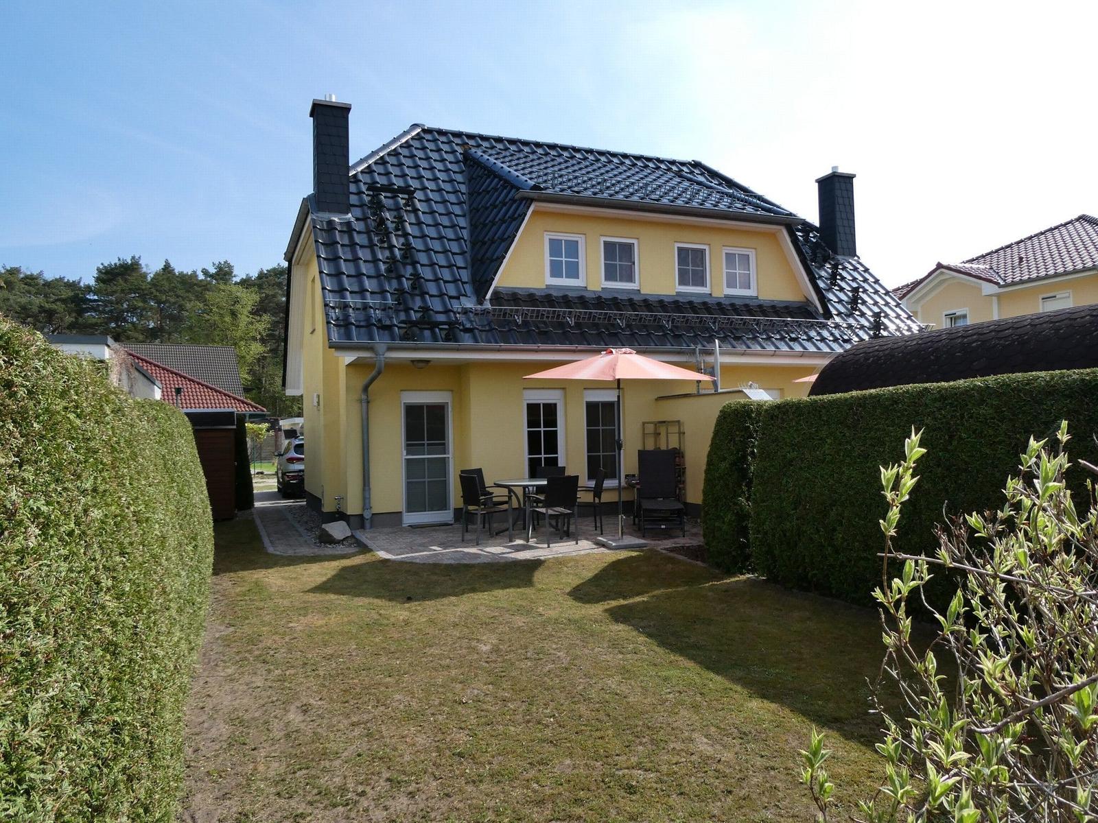 Haus mit Garten, Terrasse und Sauna. Umgeben von grünen Hecken.