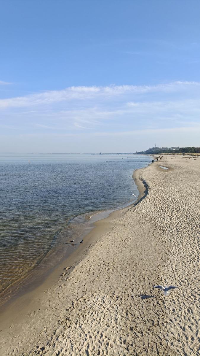 Eisiger See bei Sonnenuntergang mit schneebedeckten Ufer und Bäumen.
