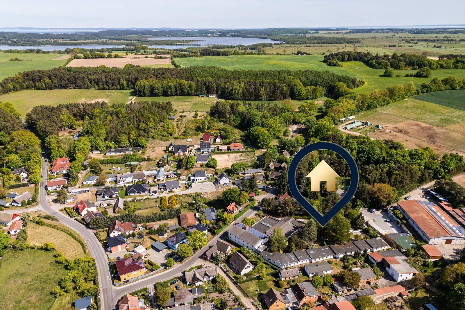 Zwei grüne Boote liegen am Ufer eines Sees, umgeben von Bäumen und Gras.