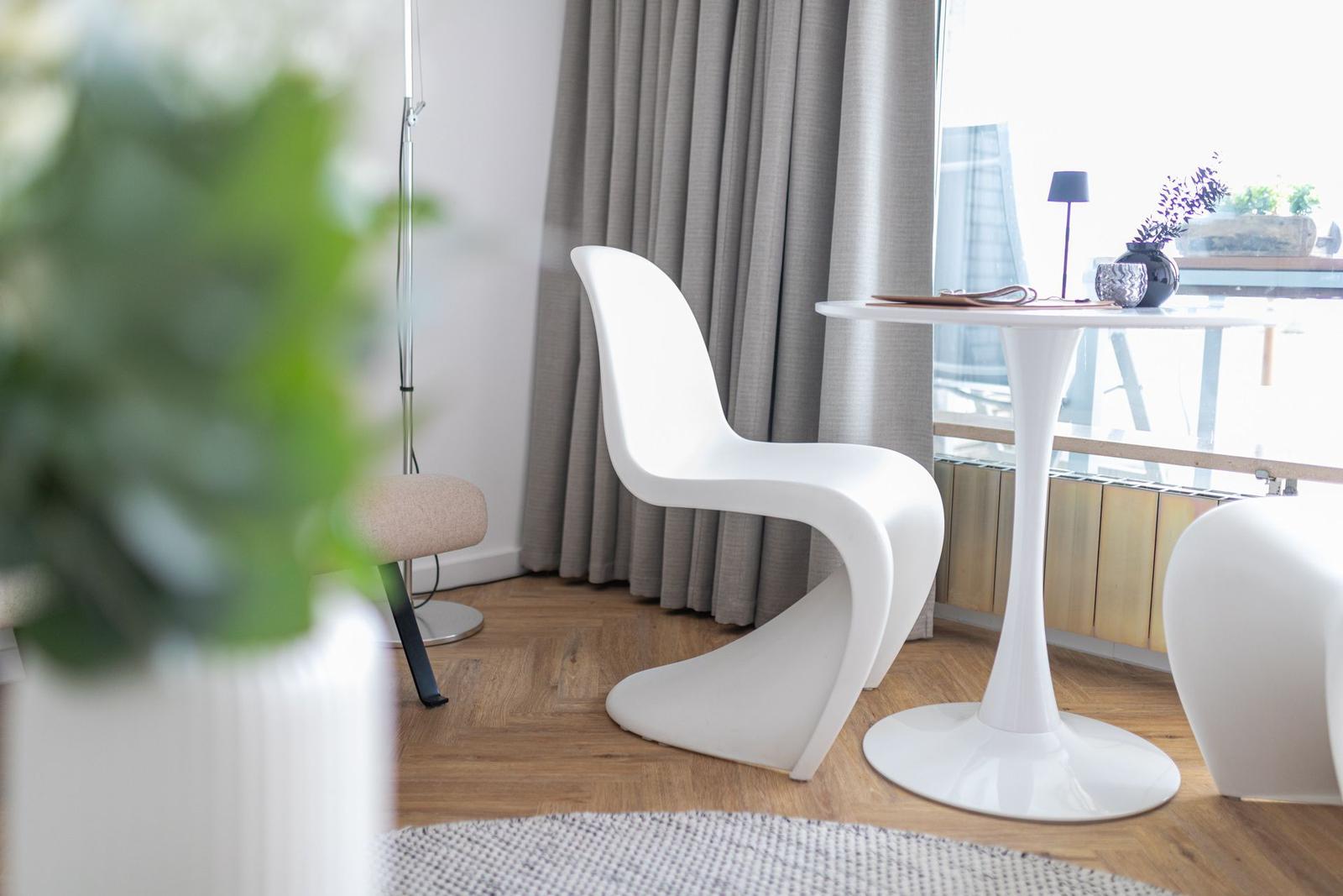 Ein Schlafzimmer mit Sofa, Bett und Holzboden. An der Wand hängt ein Bild.