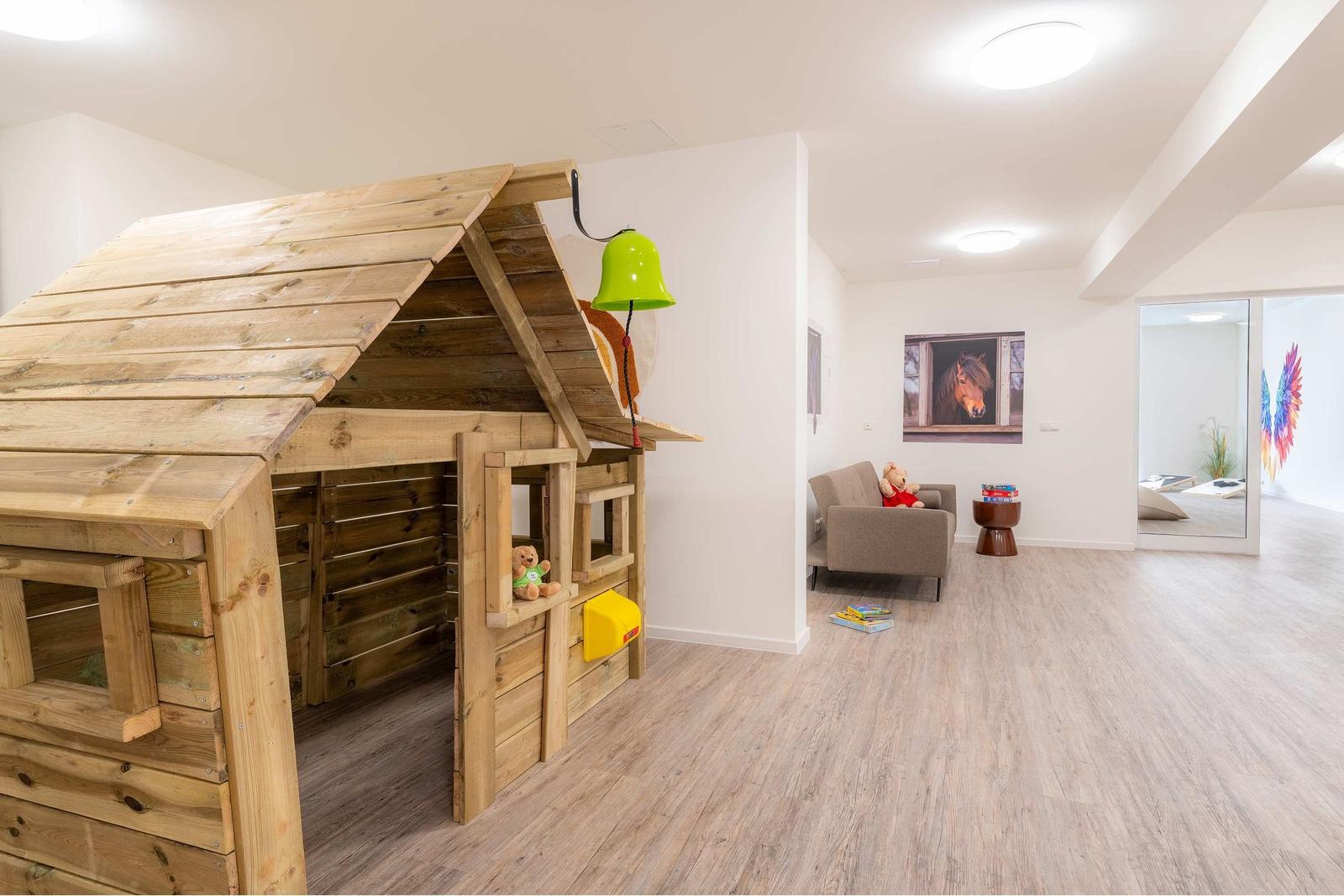 Raum mit Tischtennisplatte und Billardtisch. Wandbild mit bunten Flügeln.