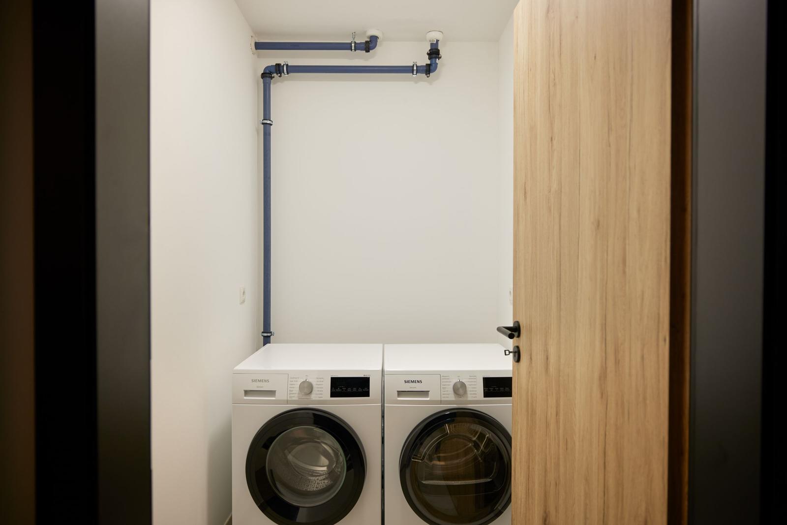 Sauna mit Holzbank, Eimer und Wandbeleuchtung.