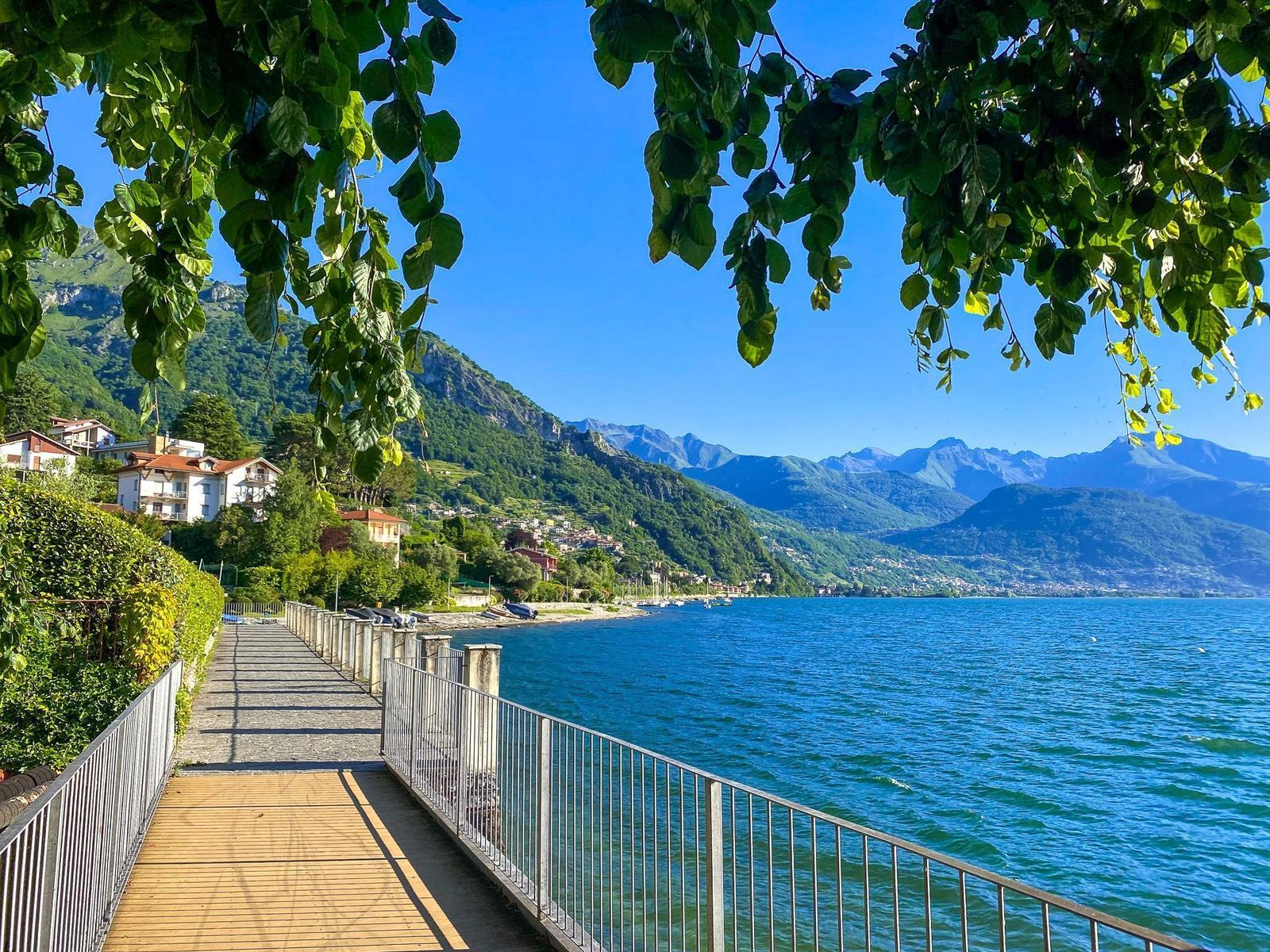 Blick auf See, Kirche und Berge unter blauem Himmel.