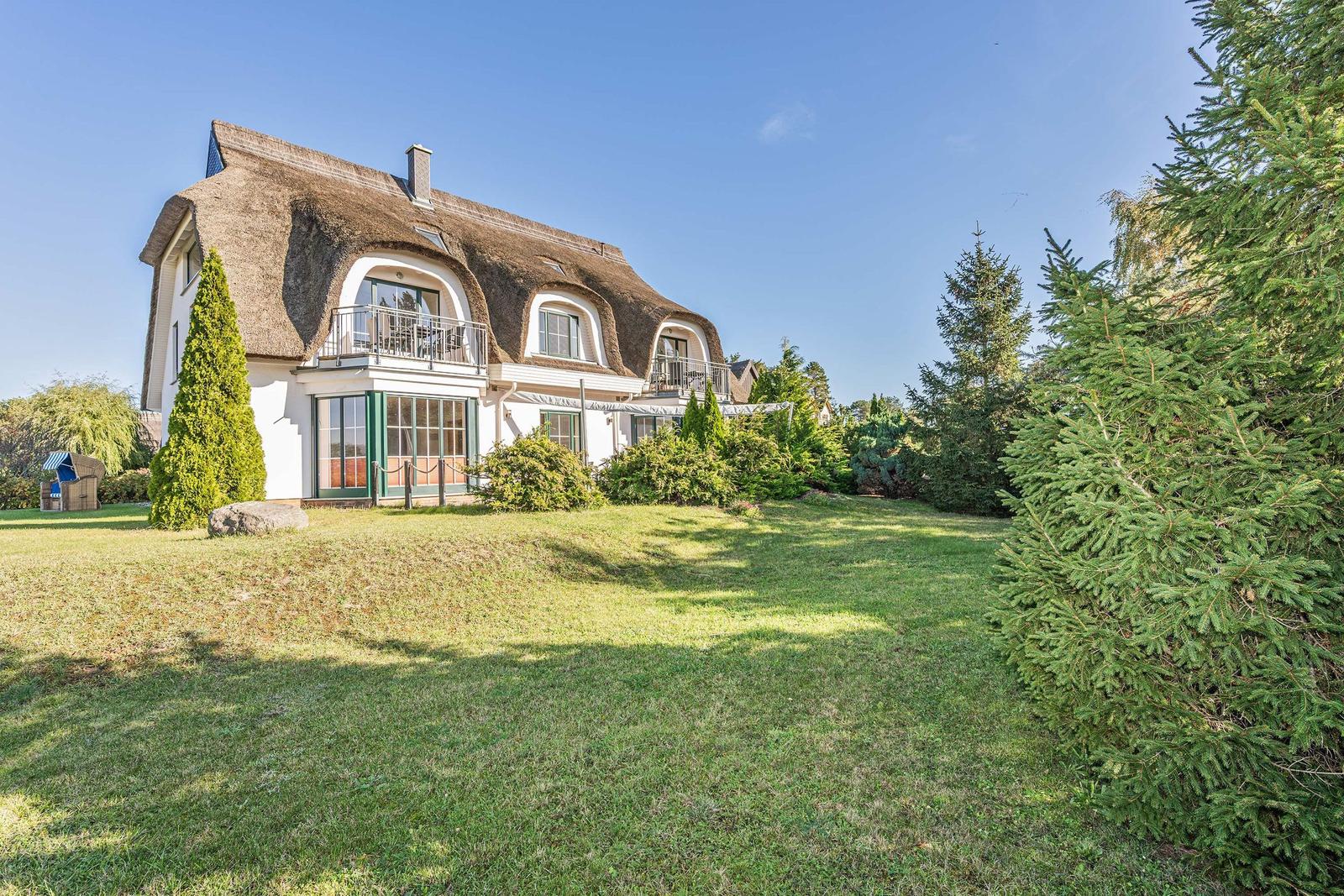 Haus in grüner Umgebung am Wasser mit Blick auf See und Felder