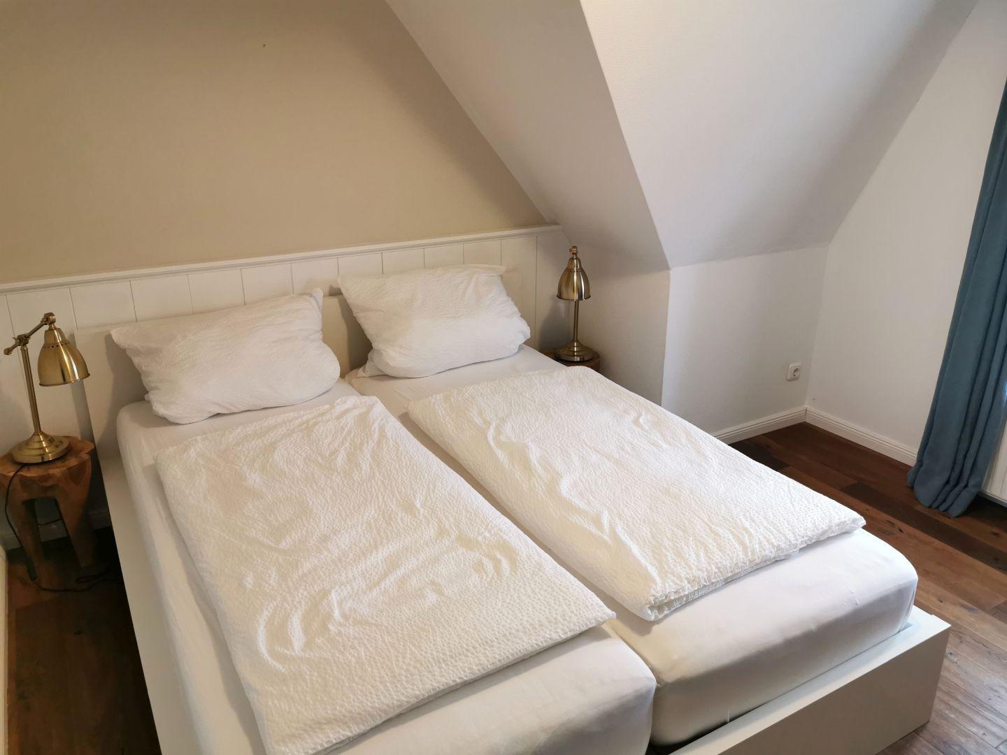 Schlafzimmer mit Bett, Kleiderschrank und Tür