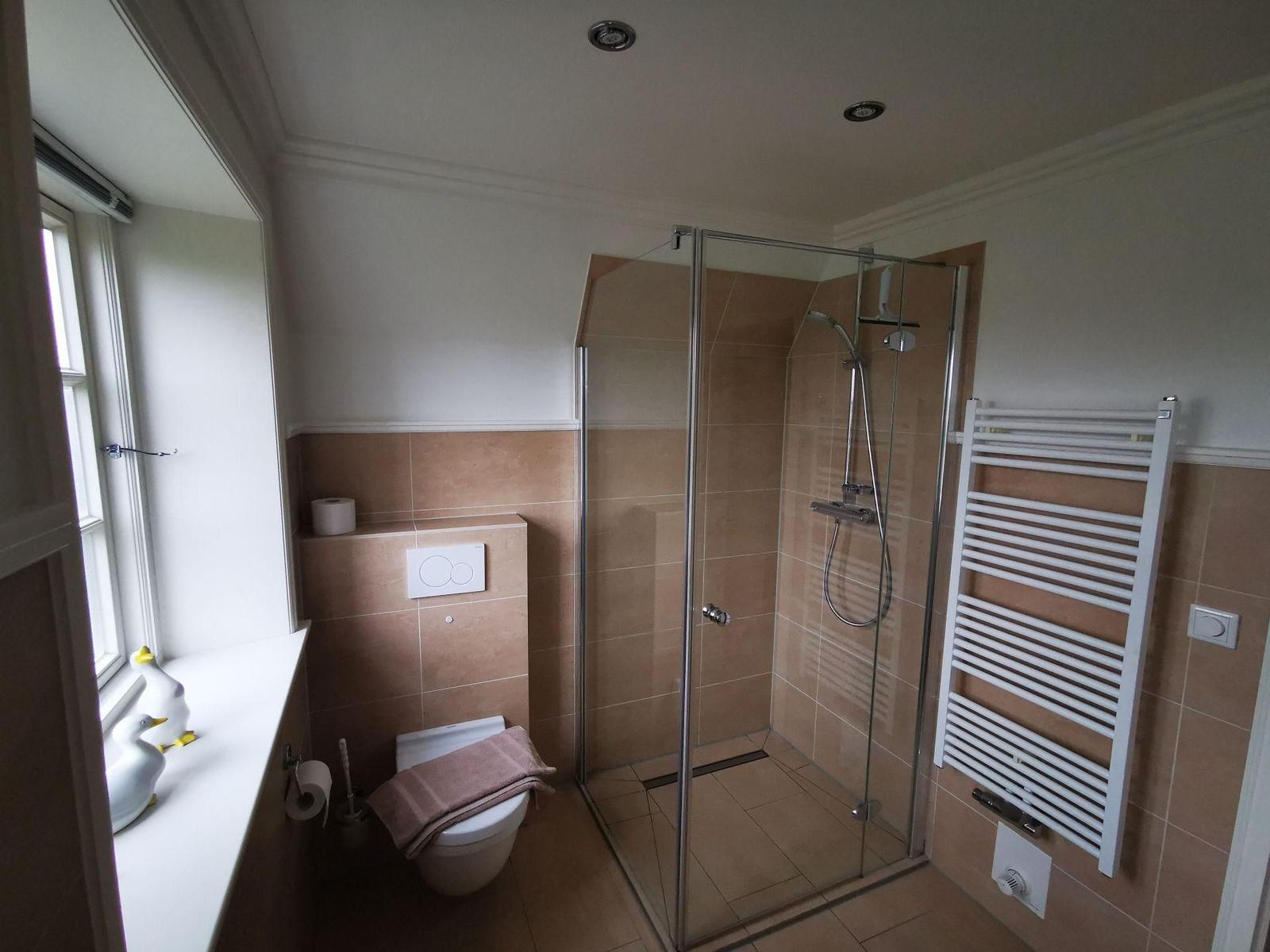 Bad mit zwei Waschbecken, Spiegelschrank und Fenster mit Blick auf Garten