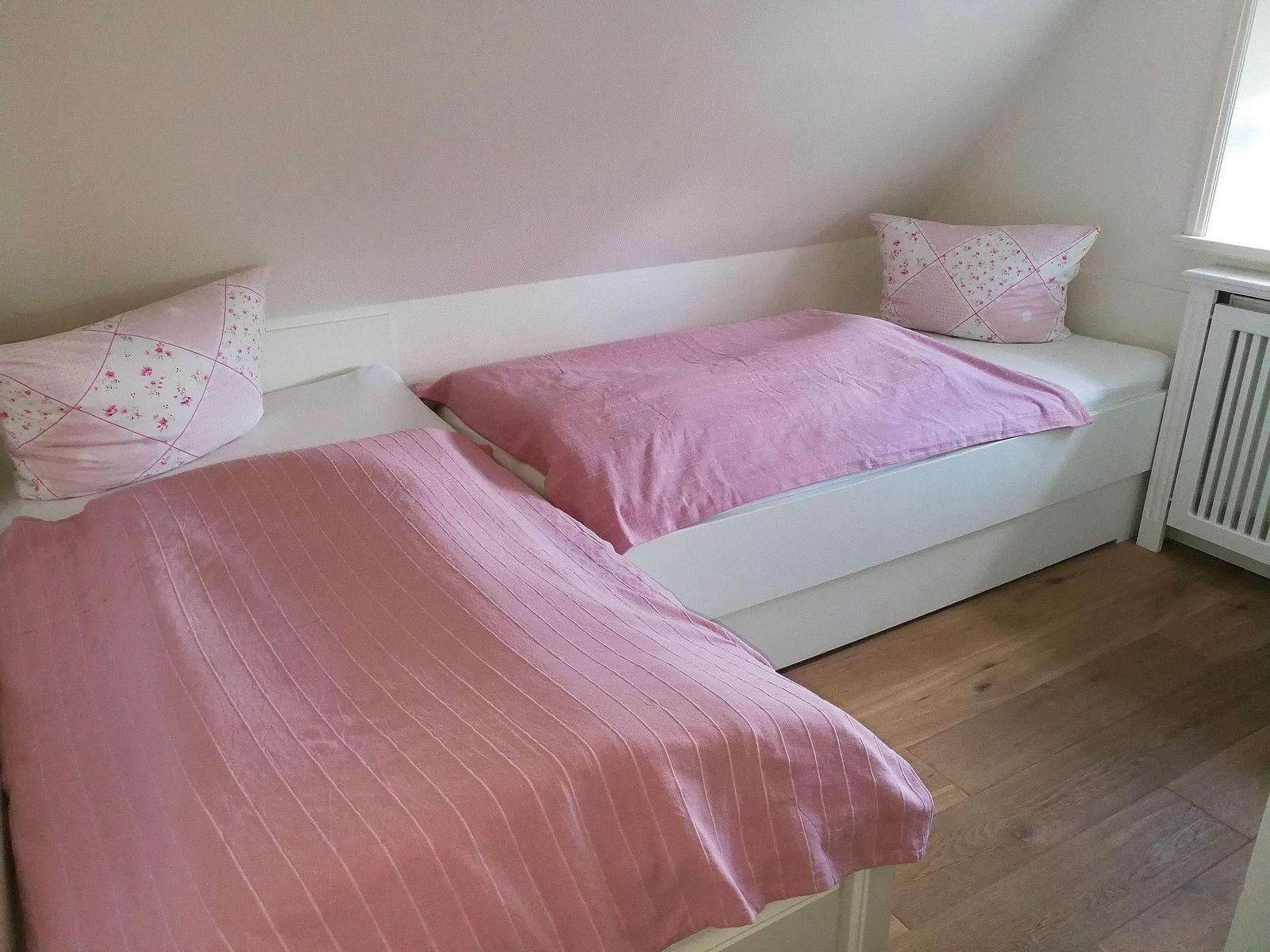 Schlafzimmer mit Bett, Fenster und Kleiderschrank