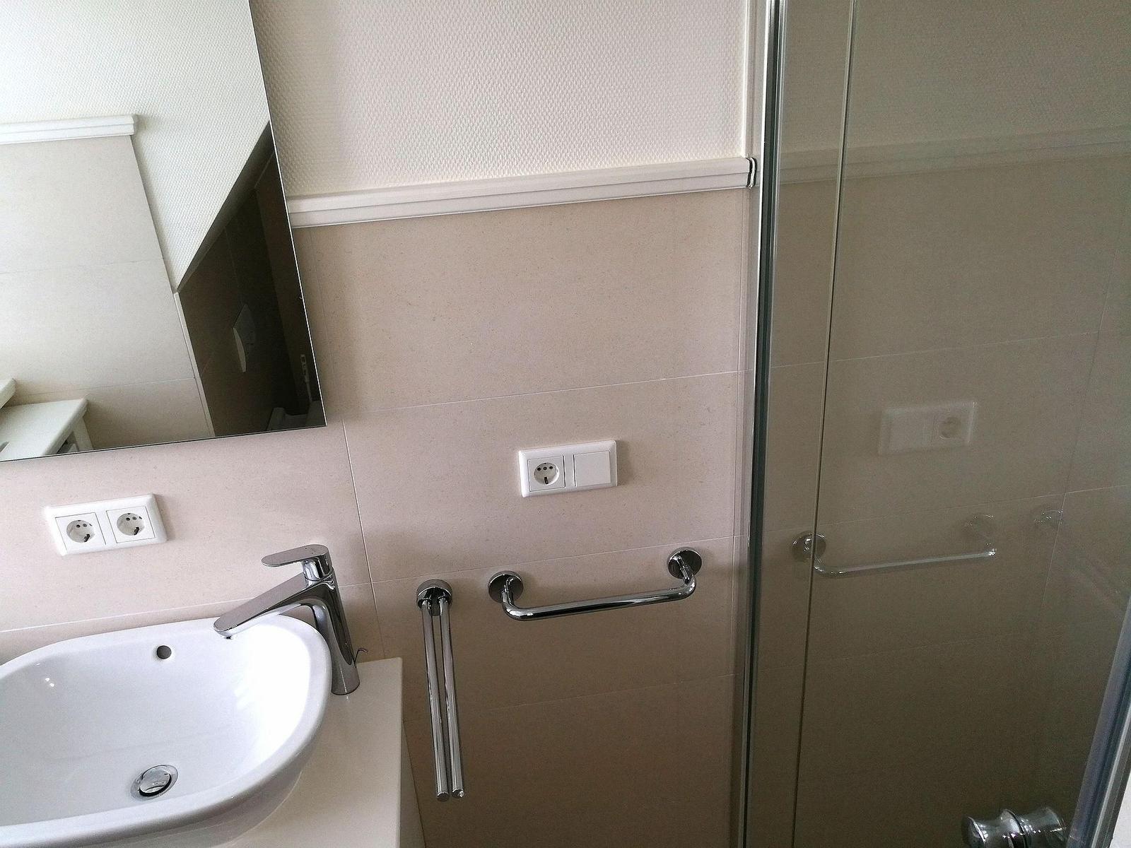 Badezimmer mit Waschbecken, Spiegel und Fenster