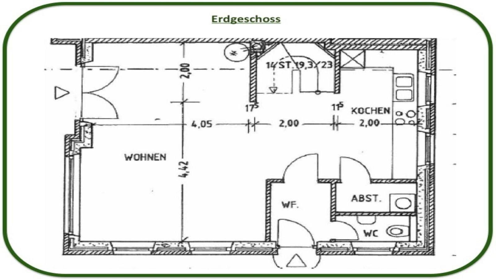 Schlafzimmer mit Dachschräge, Bett mit buntem Quilt und zwei Nachttischen mit Lampen.