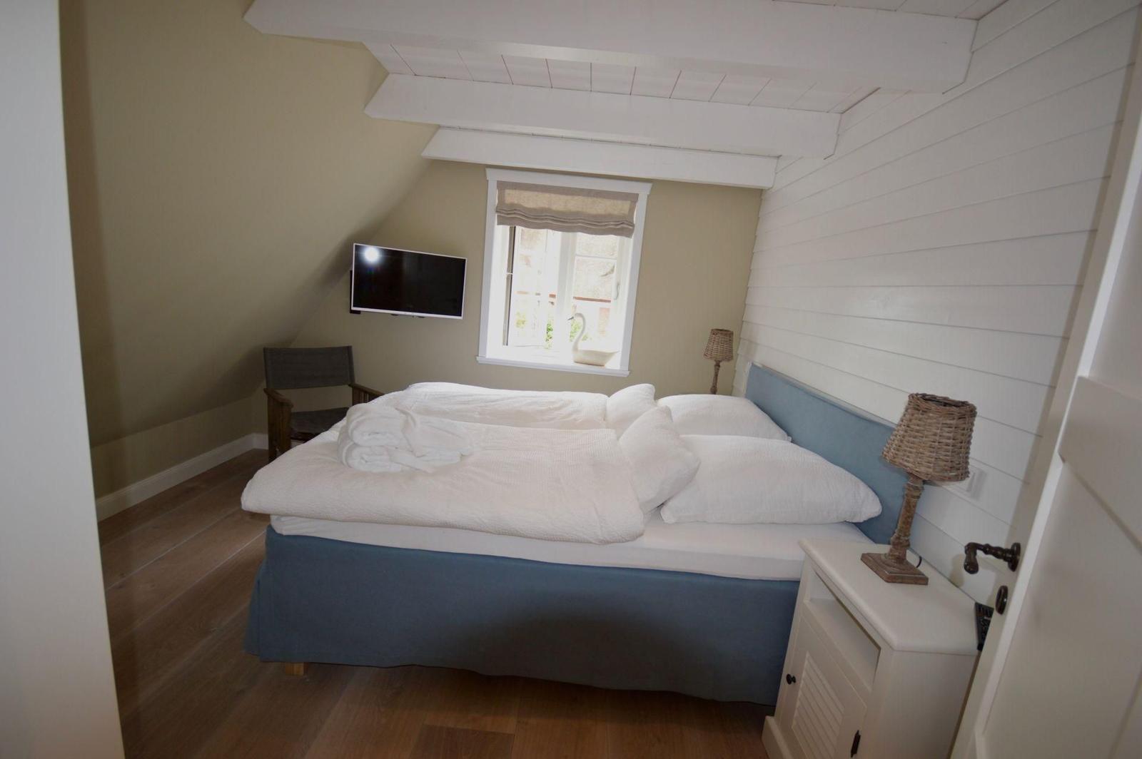 Badezimmer mit Doppelwaschbecken, Toilette und Fenster mit Blick nach draußen.