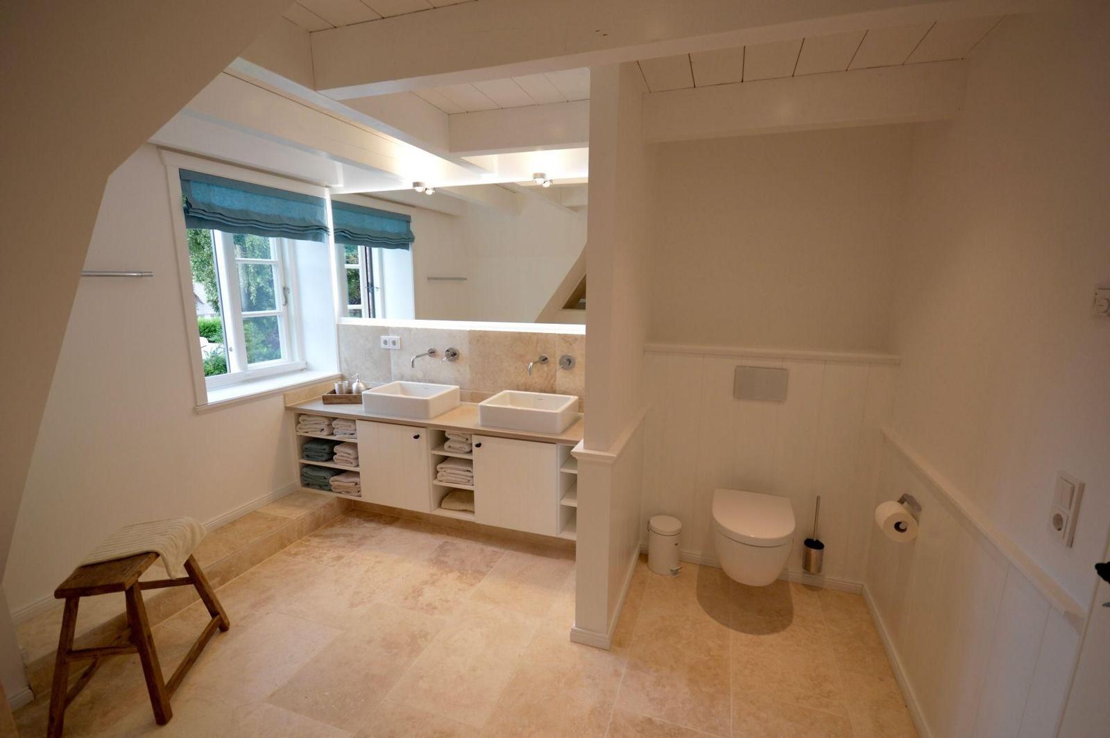 Dusche mit Glaswand und Sauna im Hintergrund